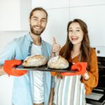 Couple with fresh breads at the kitchen